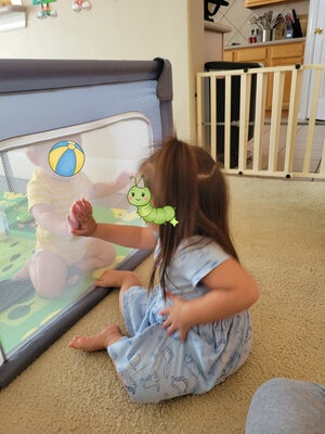 Girl and baby in playpen